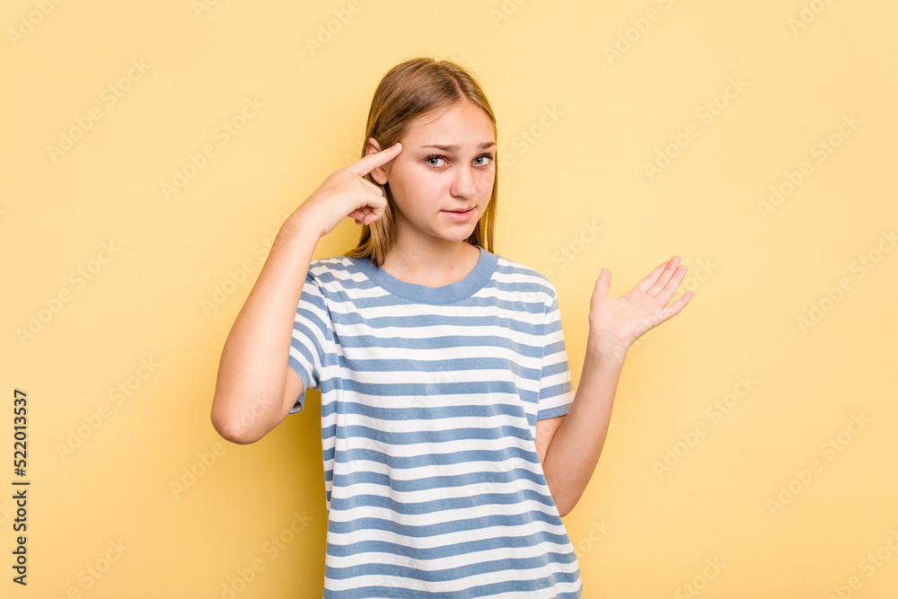 Young caucasian girl isolated on yellow background holding and showing a product on hand. Young caucasian girl isolated on yellow background holding and showing a product on hand.