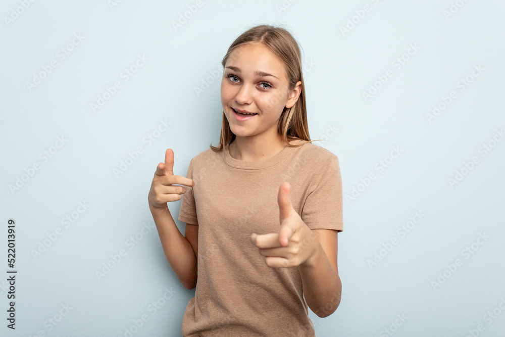 Young caucasian girl isolated on blue background cheerful smiles pointing to front. Young caucasian girl isolated on blue background cheerful smiles pointing to front.