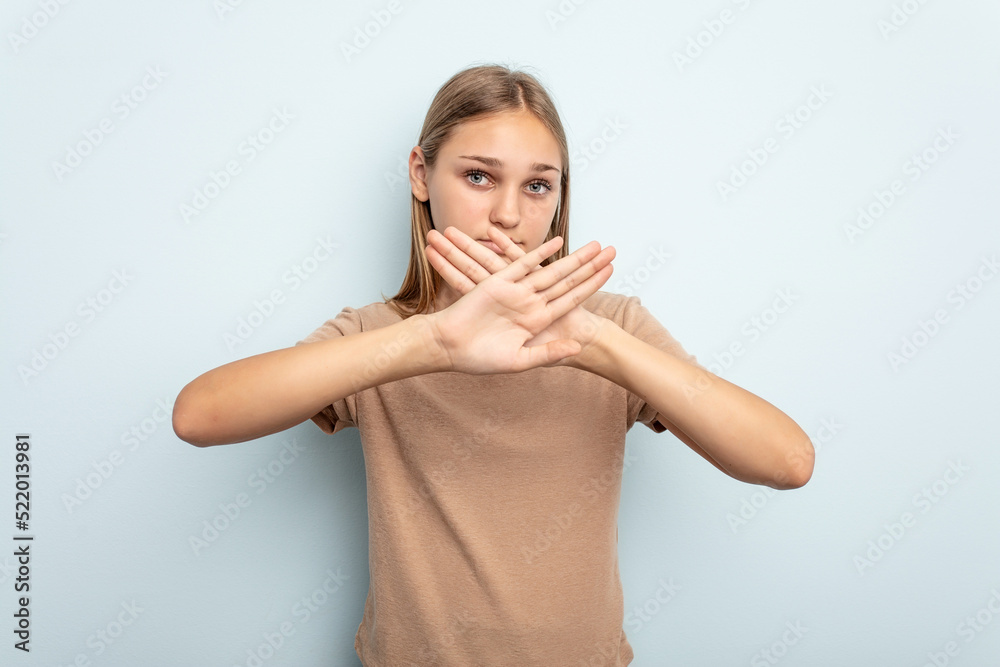 Young caucasian girl isolated on blue background doing a denial gesture Young caucasian girl isolated on blue background doing a denial gesture