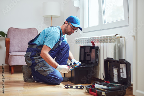 Central heating mechanic and handyman fixing home radiator, gas crisis and seasonal issues.