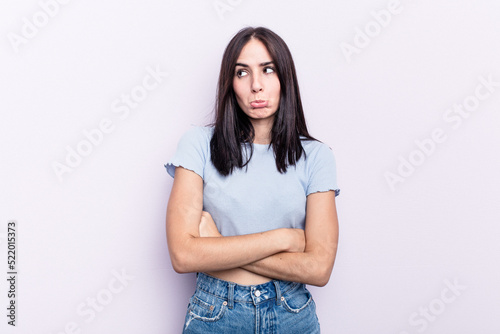 Young caucasian woman isolated on pink background tired of a repetitive task. © Asier