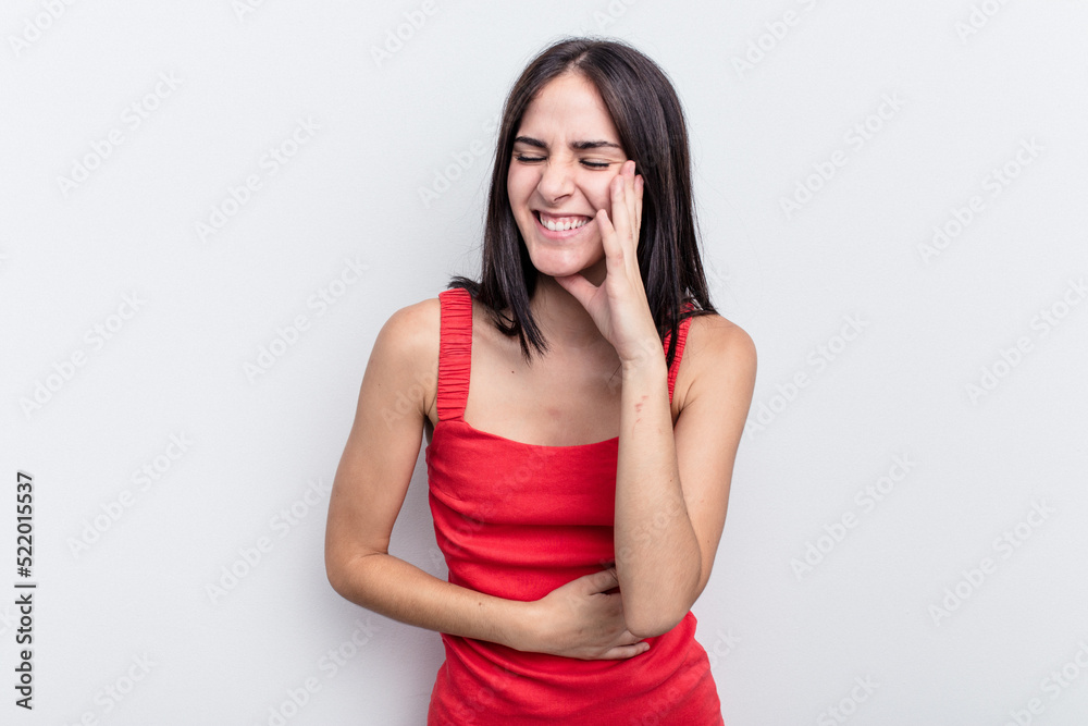Young caucasian woman isolated on white background laughs happily and has fun keeping hands on stomach. Young caucasian woman isolated on white background laughs happily and has fun keeping hands on stomach.