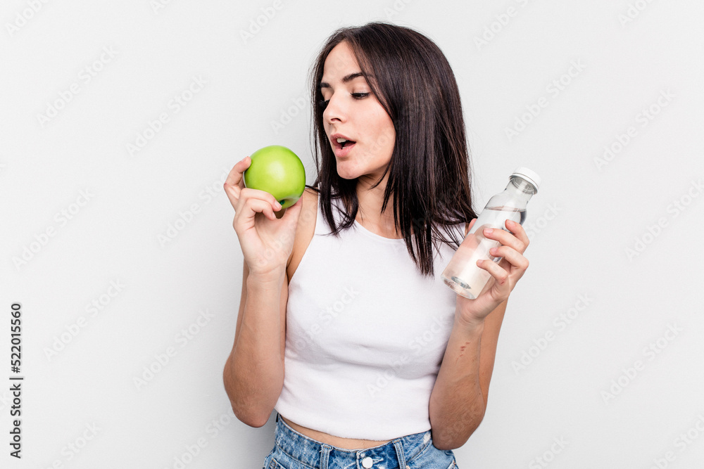 Young caucasian woman holding apple and bottle of water isolated on white background Young caucasian woman holding apple and bottle of water isolated on white background