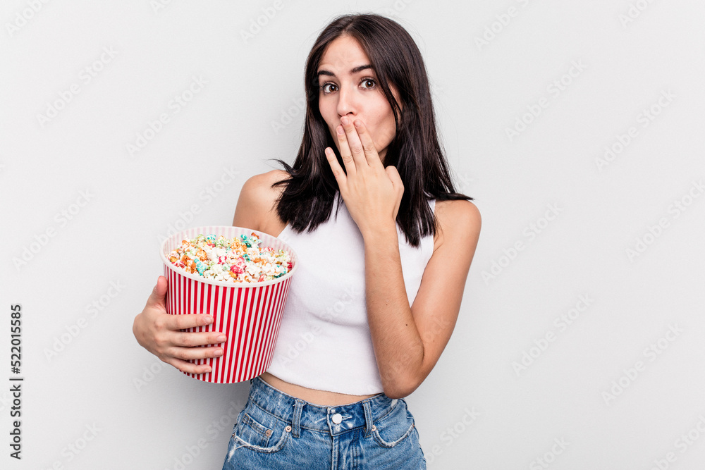 Young caucasian woman eating popcorn isolated on white background Young caucasian woman eating popcorn isolated on white background