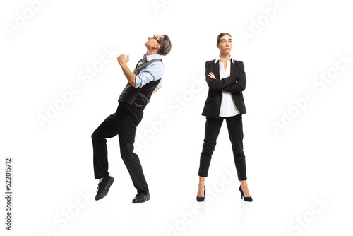Portrait of man, office manager cheerfully dancing near woman, employee isolated over white background. Successful deal