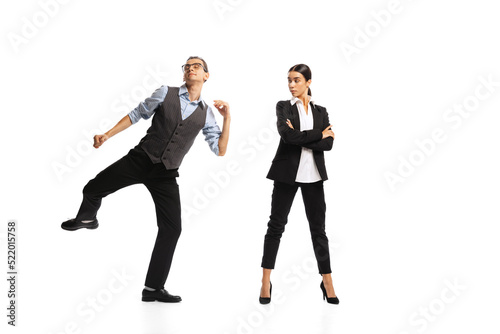 Portrait of man, office manager cheerfully dancing near woman, employee isolated over white background. Successful job