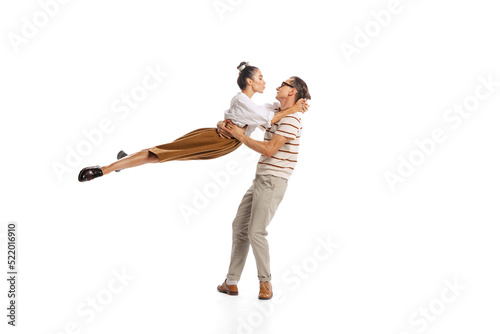 Portrait of stylish man and woman in retro outfit posing together isolated over white studio background. Romance