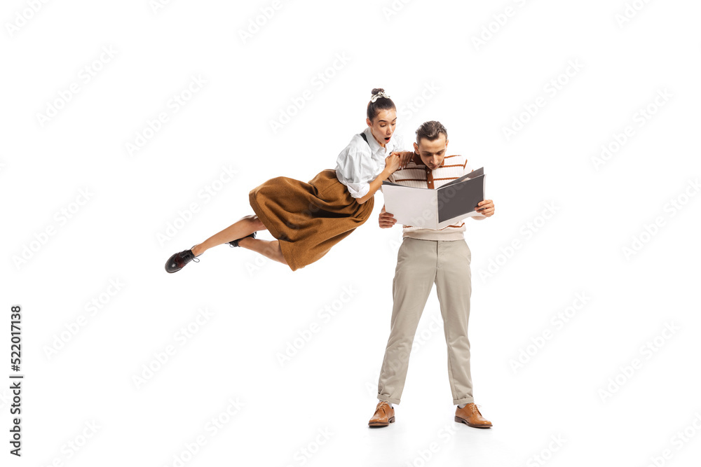 Portrait of man and woman posing isolated over white background. Employees reading business project together. Retro style Portrait of man and woman posing isolated over white background. Employees reading business project together. Retro style