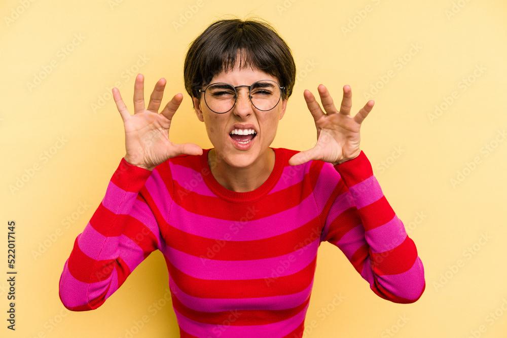 Young caucasian woman with a short hair cut isolated showing claws imitating a cat, aggressive gesture. Young caucasian woman with a short hair cut isolated showing claws imitating a cat, aggressive gesture.