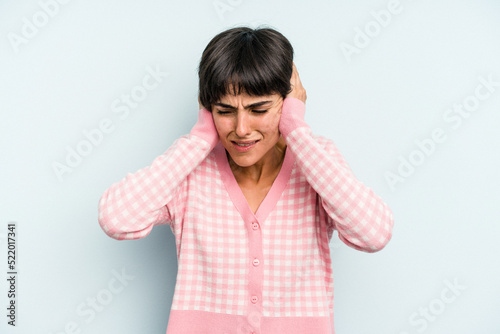 Young caucasian woman with a short hair cut isolated covering ears with hands.