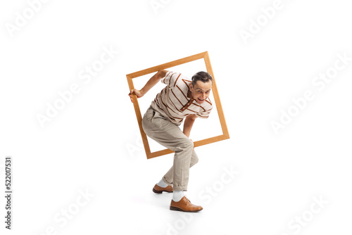 Portrait of stylish man appearing from picture frame isolated over white background. Retro style