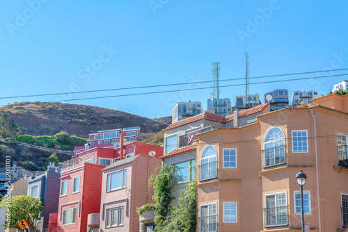 Photography Rowhouses and apartment buildings near the mountain with two cell towers on top