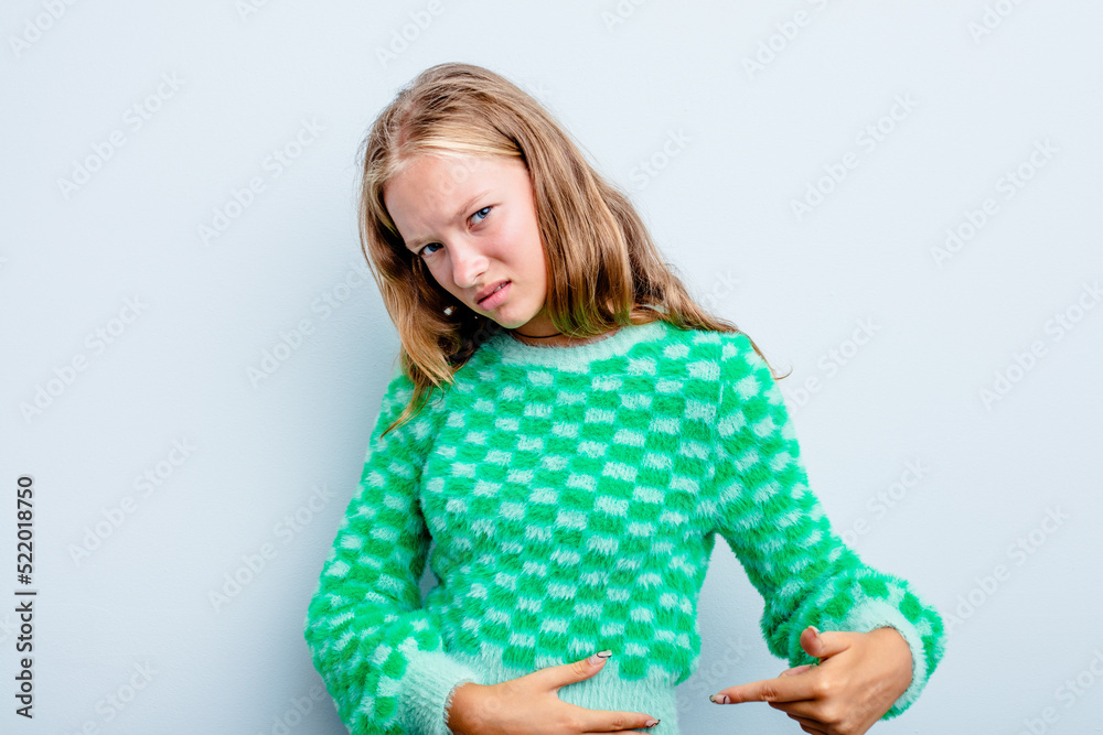 Caucasian teen girl isolated on blue background having a liver pain, stomach ache. Caucasian teen girl isolated on blue background having a liver pain, stomach ache.