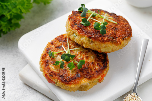 Foto Vegan cutlets made with quinoa and vegetables, served with microgreens