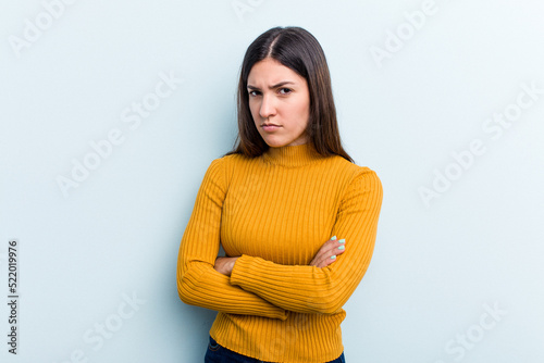 Young caucasian woman isolated on blue background suspicious, uncertain, examining you.