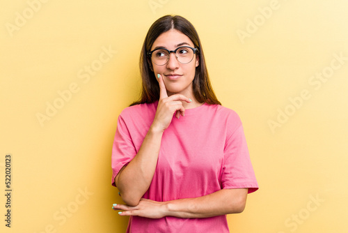 Young caucasian woman isolated on yellow background contemplating, planning a strategy, thinking about the way of a business.