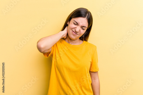Young caucasian woman isolated on yellow background having a neck pain due to stress, massaging and touching it with hand.