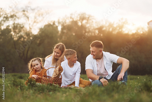 Sitting on the green grass. Family have weekend outdoors at summertime together