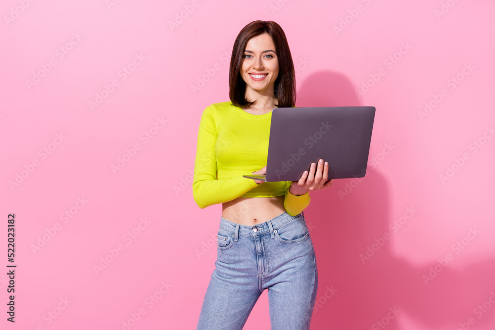 Photo of pretty charming girl dressed lime shirt holding modern device isolated pink color background Photo of pretty charming girl dressed lime shirt holding modern device isolated pink color background