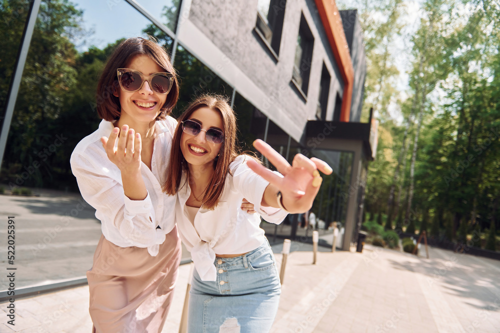 At sunny daytime. Two female friends have great weekend outdoors together At sunny daytime. Two female friends have great weekend outdoors together