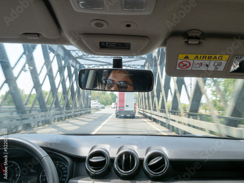 indian young woman driving a car suv in the mountain road a rainy cloudy day photo