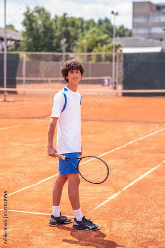 Young boy with racket on tennis court smiling © spoialabrothers