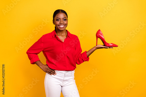 Photo of young lady promoter present stilettos suggest promo discount isolated over yellow color background