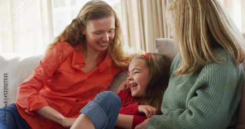 Video of happy caucasian daughter tickled by mother and grandmother sitting on couch