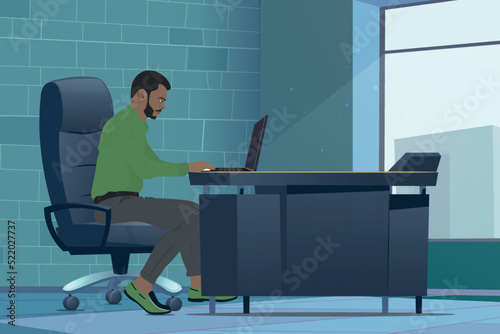Fototapeta Young black business man in green set in office working on laptop, Gulf business