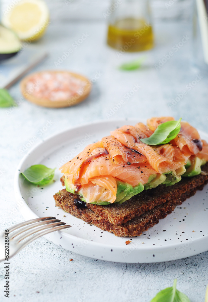 A rye bread sandwich with avocado and salmon