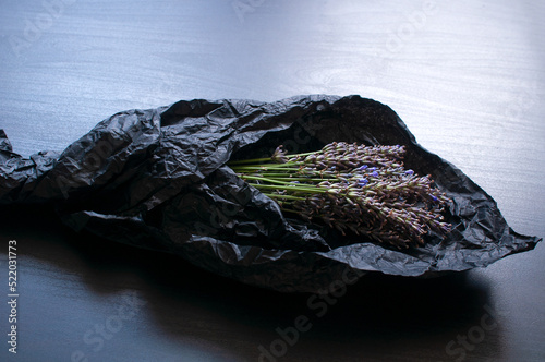 Bouquet of fragrant fresh lavender flowers on black crumpled wrapping paper background