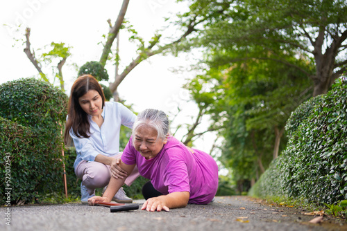 Asian senior woman fell down on lying floor because faint and limb weakness and Crying in pain form accident and her daughter came to help support. Concept of old elderly insurance and health care