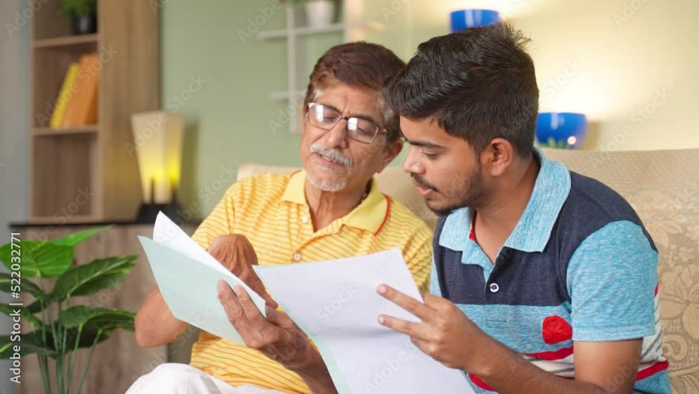 Grandfather with son discussing about education or property documents at home - concept of Medical insurance, financial debt and Mortgage