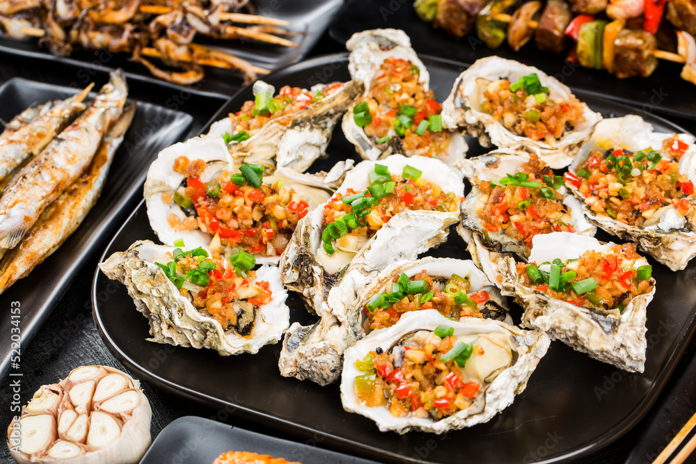 Various barbecue delicacies are placed on the black wood background Various barbecue delicacies are placed on the black wood background