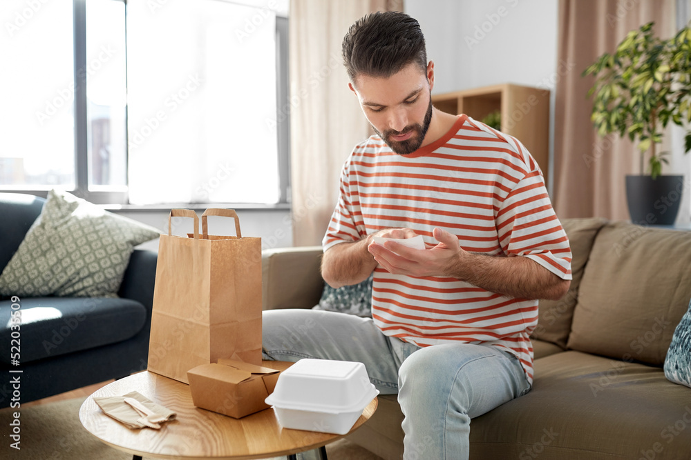 communication, leisure and people concept - man with bill checking takeaway food order at home communication, leisure and people concept - man with bill checking takeaway food order at home