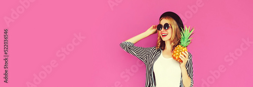 Summer portrait of happy smiling woman with pineapple wearing black round hat, sunglasses on pink background, blank copy space for advertising text