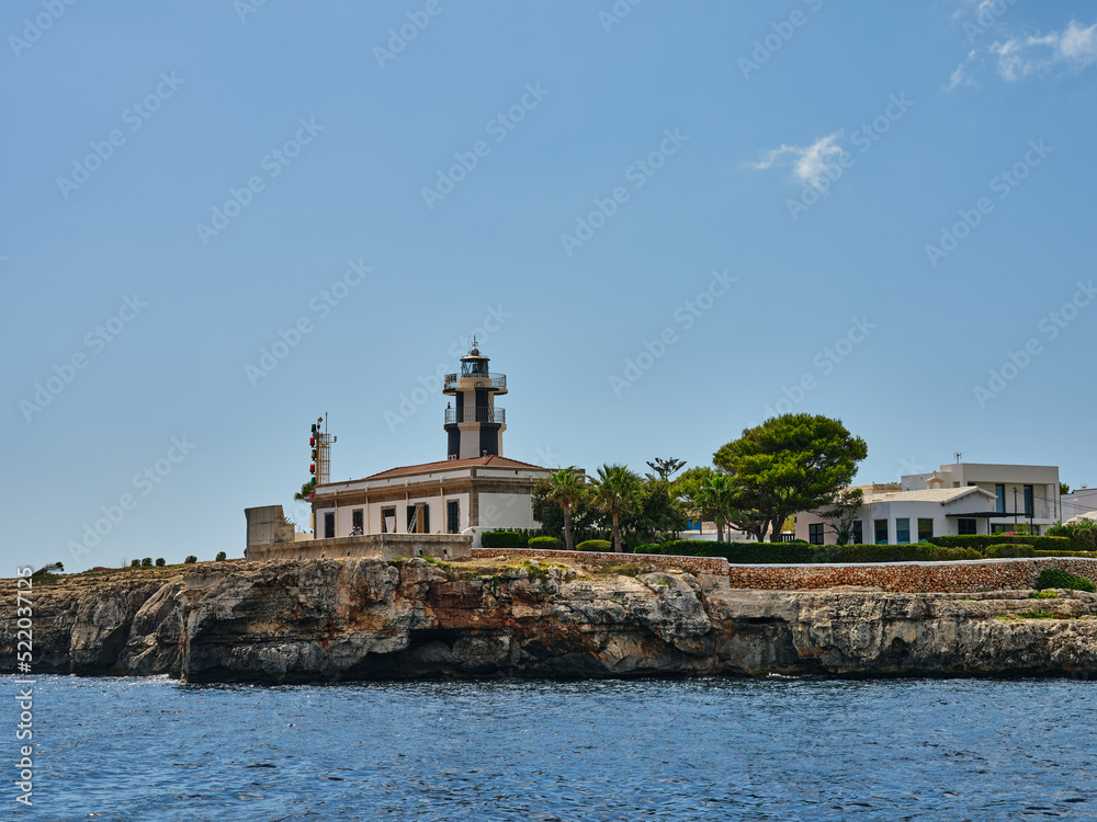 A lighthouse on a rocky cliff on the island of Menorca, Spain