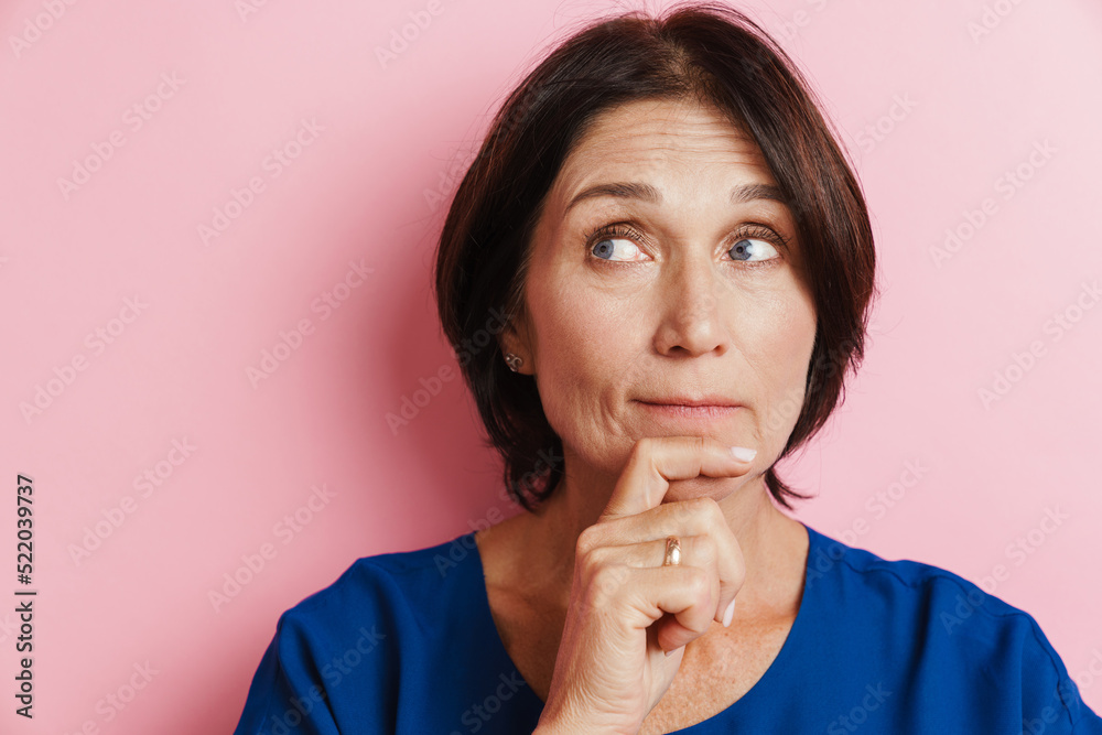 Mature brunette woman frowning and looking aside Mature brunette woman frowning and looking aside