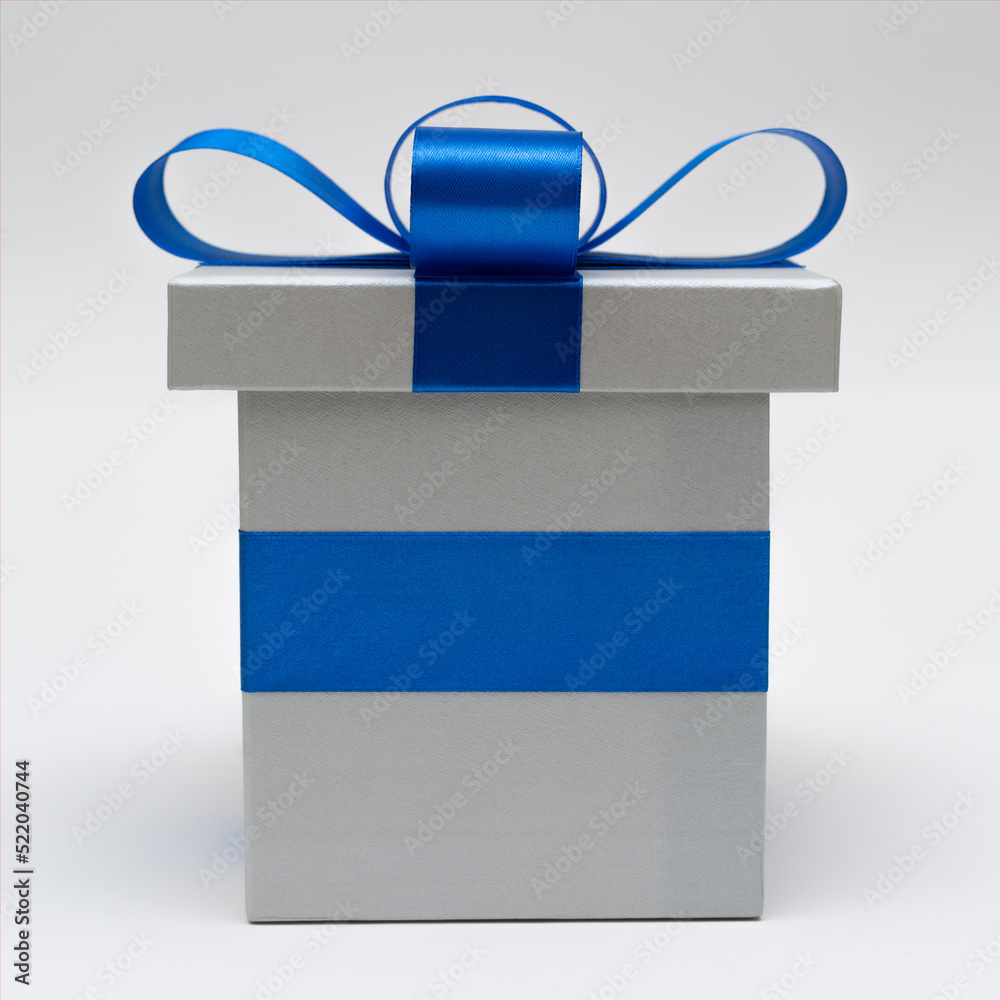 silver gift box with blue satin bow ribbon on white background silver gift box with blue satin bow ribbon on white background