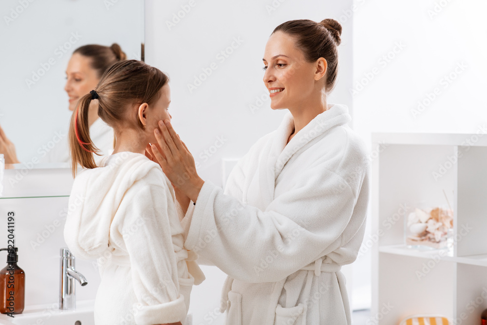beauty, family and people concept - happy smiling mother and little daughter in bathroom beauty, family and people concept - happy smiling mother and little daughter in bathroom