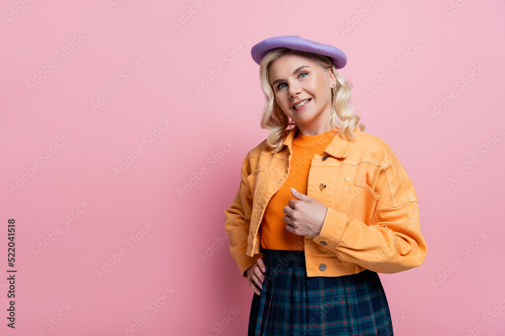 Stylish woman in beret holding hand on hip on pink background Stylish woman in beret holding hand on hip on pink background