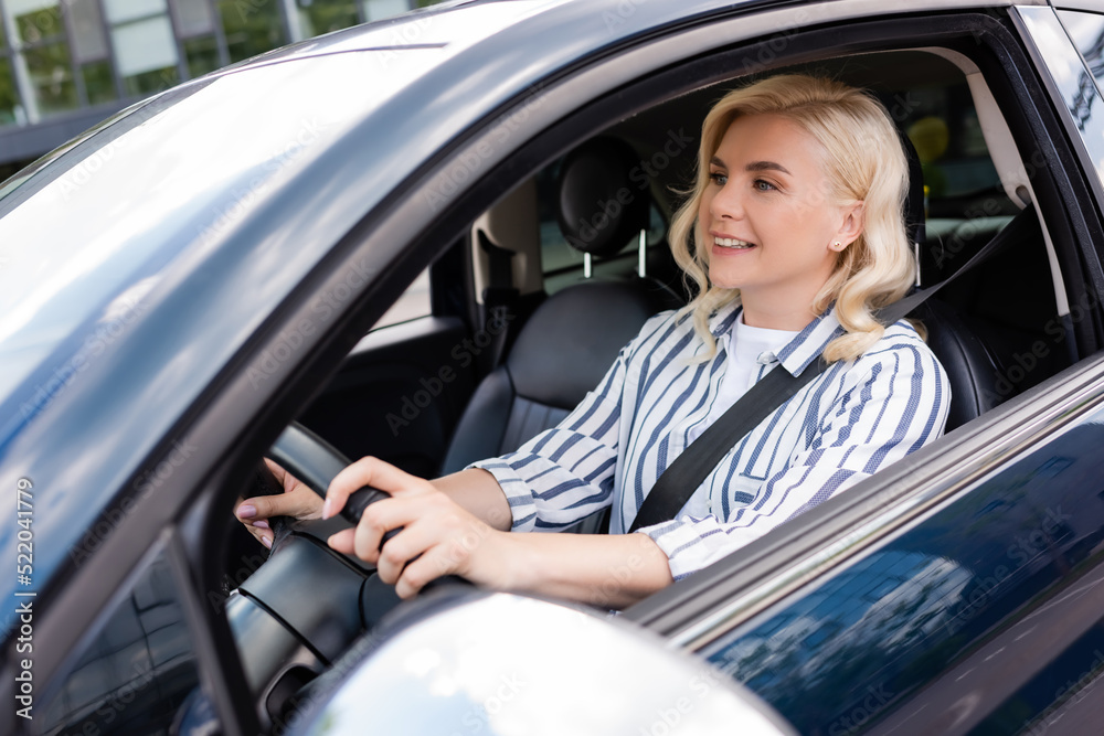 Cheerful woman looking away during driving courses in car Cheerful woman looking away during driving courses in car