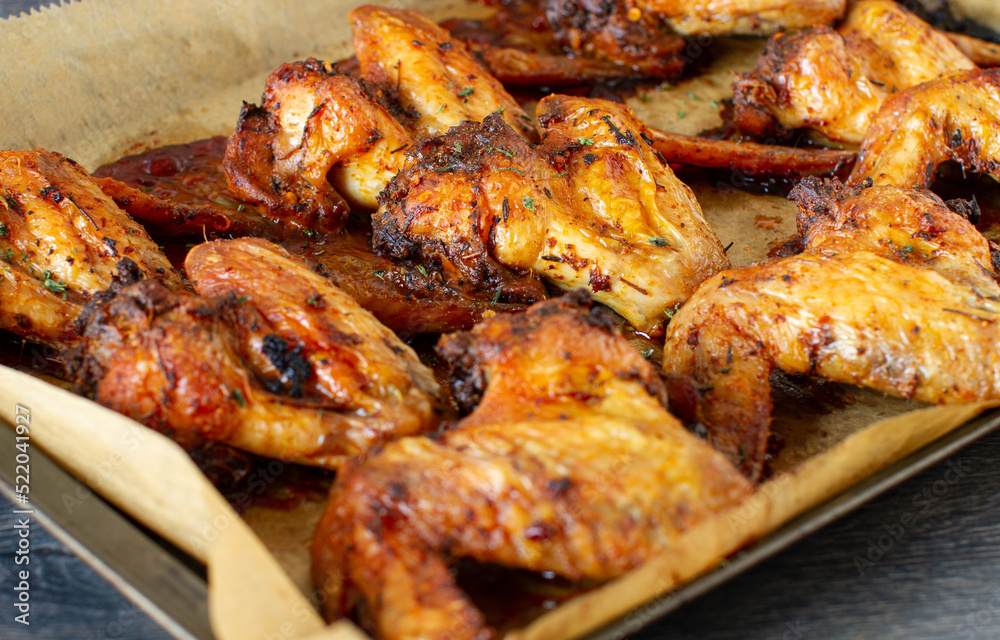 Roasted chicken wings on baking tray  background, ready to eat