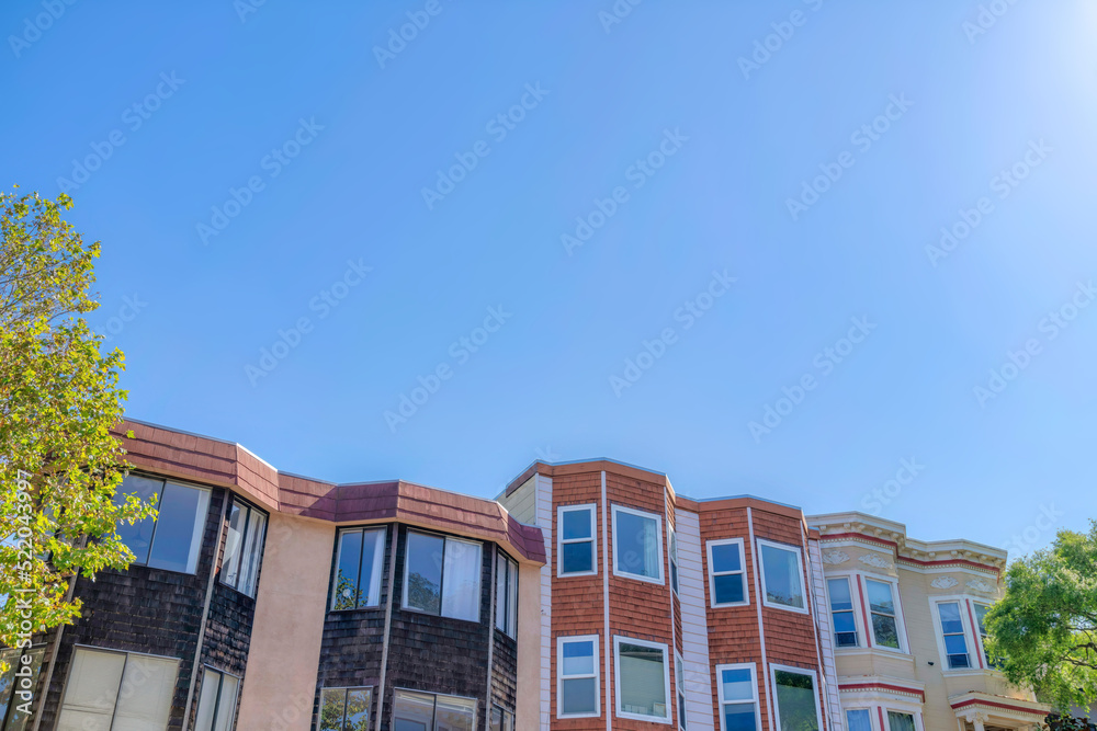Fototapeta premium Rowhouses with bay windows against the clear sky in San Francisco, CA