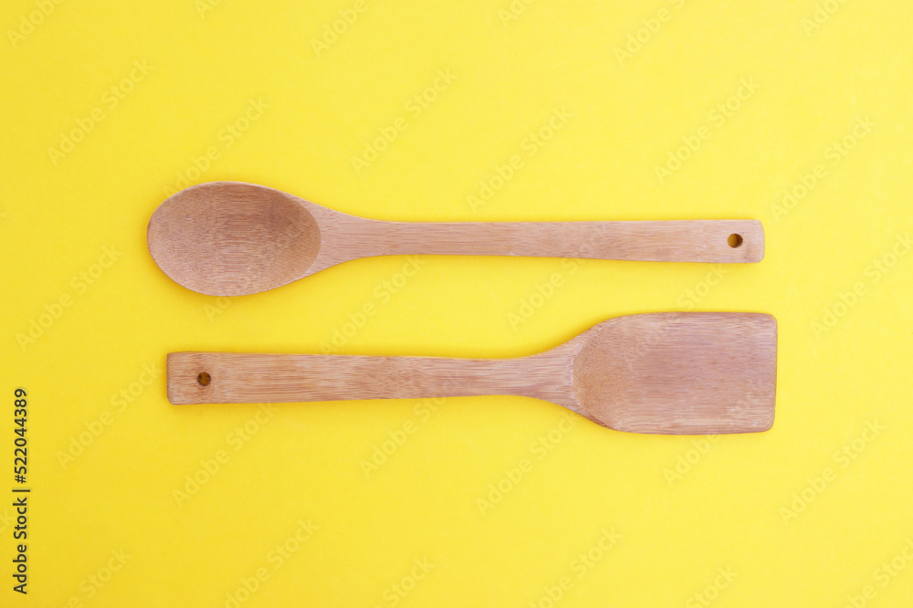 A set of bamboo dishes on a bright yellow background. A set of bamboo dishes on a bright yellow background.