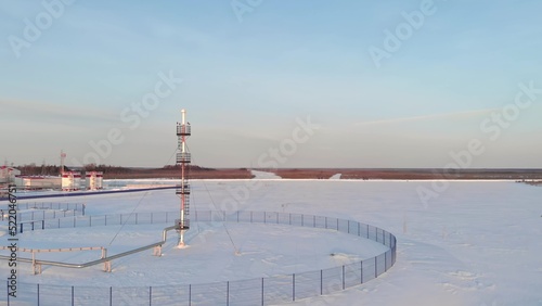 A drone flies over an emergency gas release tower at an oil and gas refinery. Gas production in Russia in Siberia in winter. Oil and gas industry of the Russian Federation. Industry in winter.