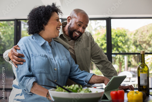 Mature black couple preparing a healthy meal using a digital tablet