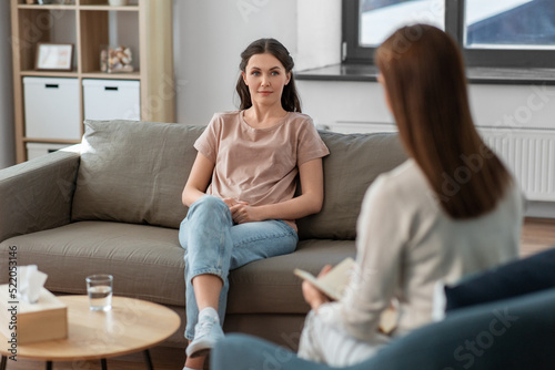 psychology, mental health and people concept - young woman patient and woman psychologist at psychotherapy session photo