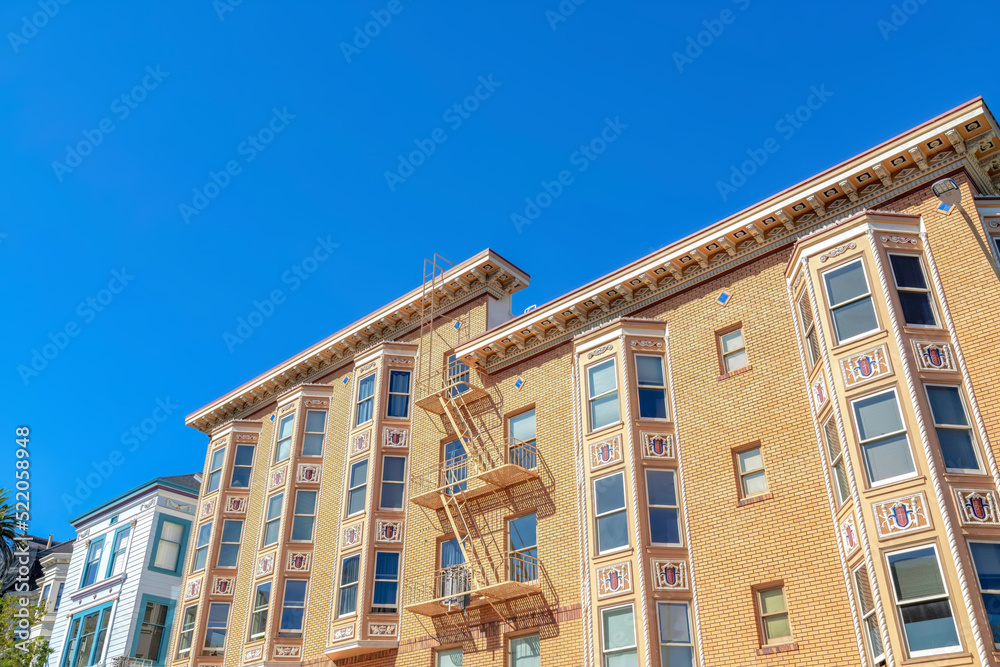 Apartment building with decorative window exterior and emergency stairs at San Francisco, CA
