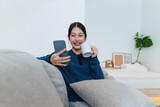 Lifestyle concept. Happy young woman using cell phone on sofa at home